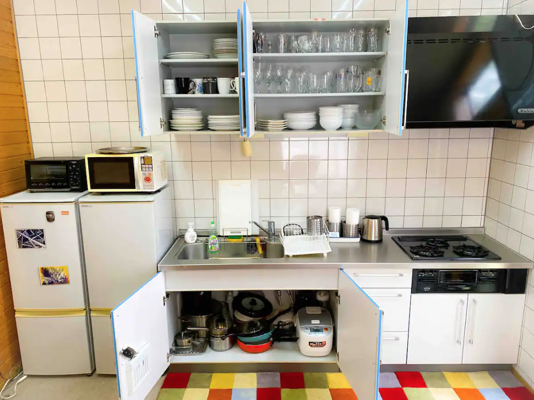 Kitchen with cooking equipments, cups, plates, utensils 